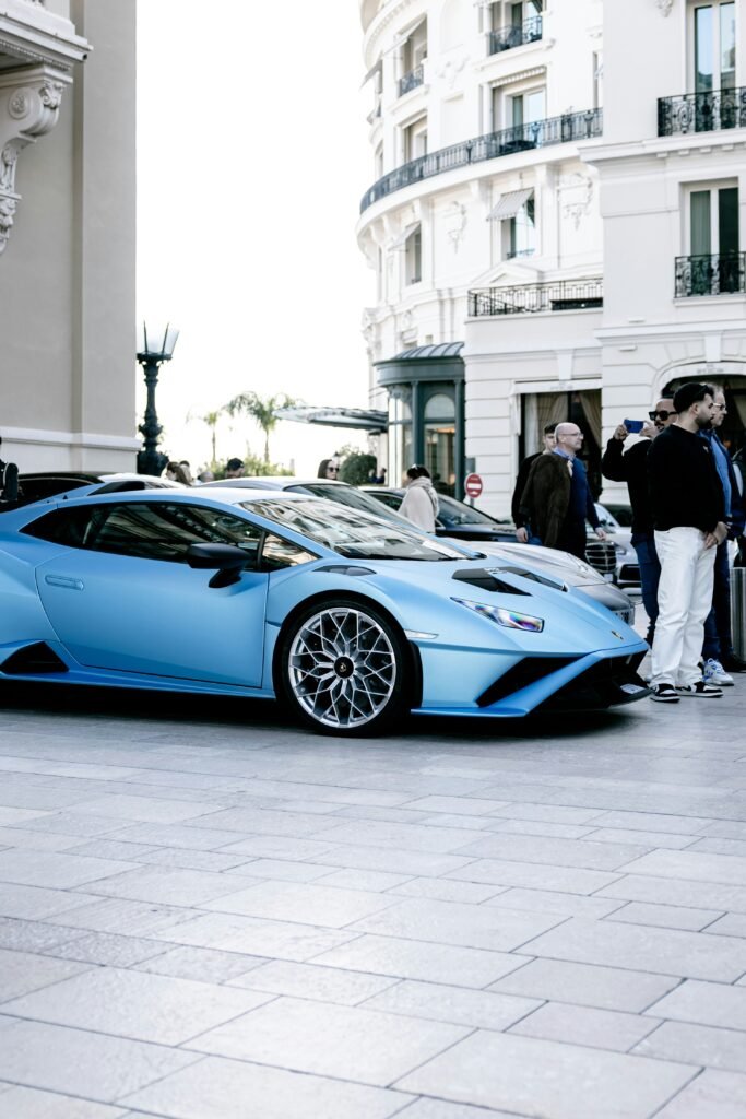 Voiture de luxe bleu mat garée devant un hôtel de prestige à Monaco