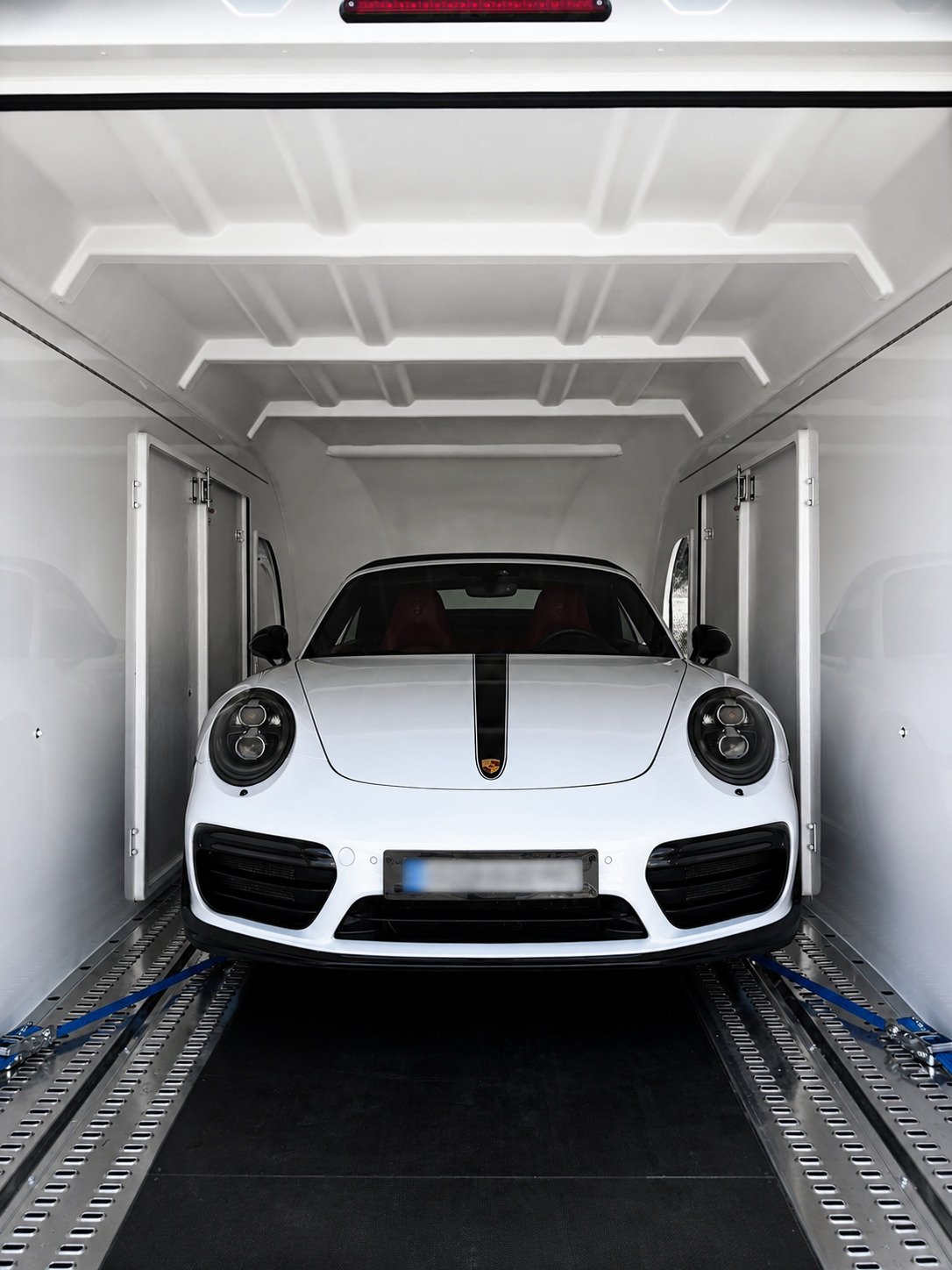 Porsche 911 Turbo S blanc chargée et arrimée dans une remorque fermée pour transport sécurisé porte à porte Monaco‑Italie