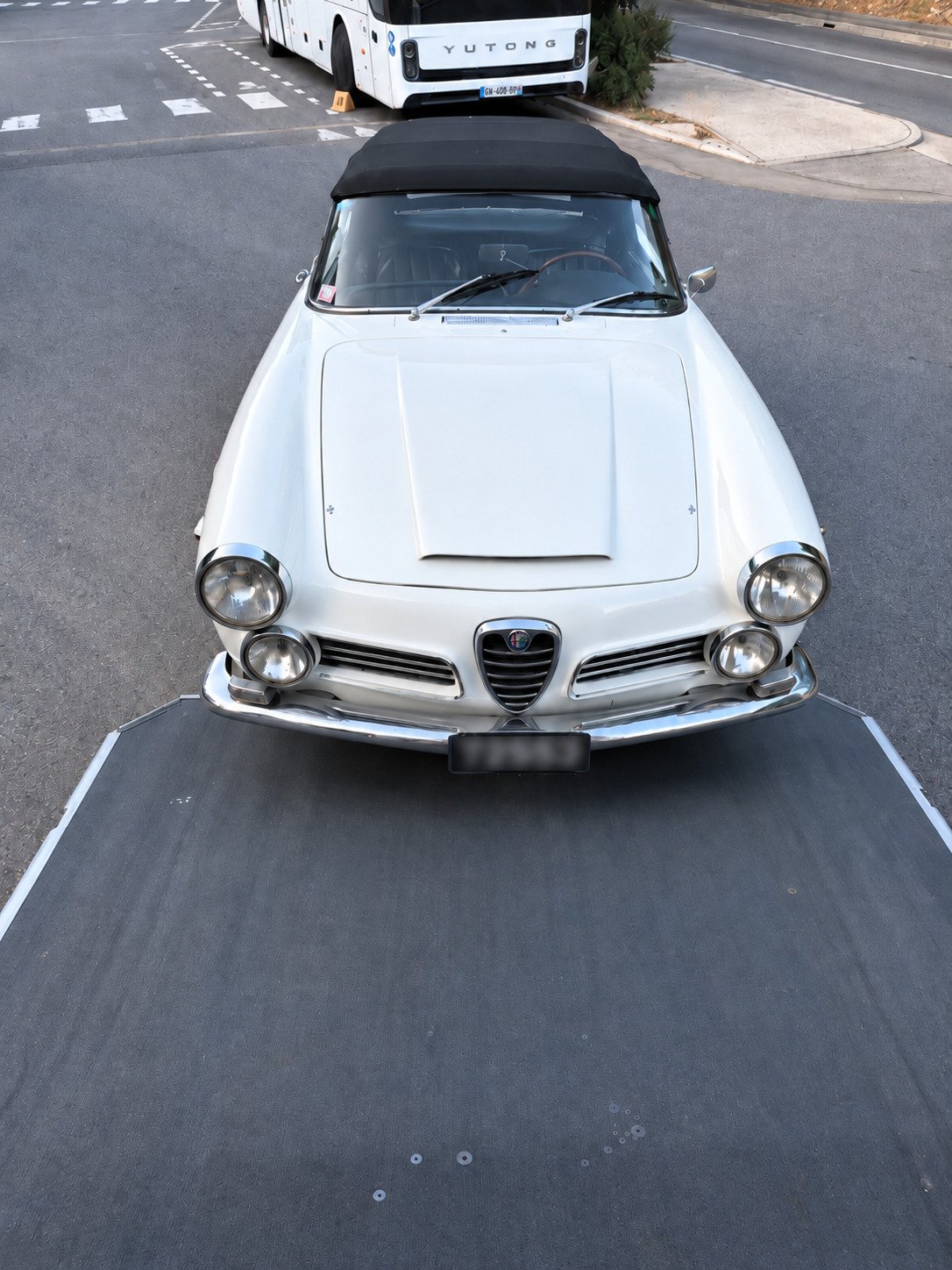 alfa romeo en train d'être chargée dans une remorque de transport fermée